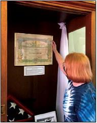 Georgia Smith adjusts an original document her father received in World War II