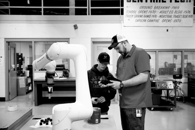 Zach Ihle teaches a student how to use the Cobot robotic arm in Central Tech’s Industrial Automation program. courtesy photo