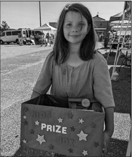 The Artisans and Gardeners Market enjoyed a day of fun, games, and cool weather on Saturday. The Sitter Family Farm brought all kinds of furry and feathered friends as well as ponies. The vendors had the best time creating a scavenger hunt and putting together over $300 worth of prizes. Pictured is Rylee, the winner of the kids' prize basket full of vendor created goodies.
