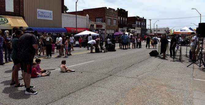 Bristow's Community Band included Wake Tidwell, Chapman Shields and a vocalist to sing and play popular songs. Picured left, A member of the Tulsa Raqs Belly Dance group balances a sword on her head. Behind her, a girl joins the fun by dancing too.