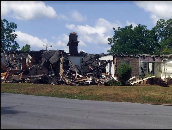 Angie Gentry photo Firefighters work diligently to save this brick home, on the corner of 5th and Ash, but the fire spread quickly and the home was a total loss.