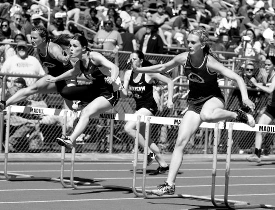 Carlie Capps and Ava Yocham run the hurdles.
