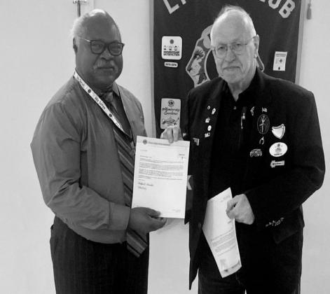 Melvin Taylor is presented an award by District Governor David Wooddall for 10 years of service.