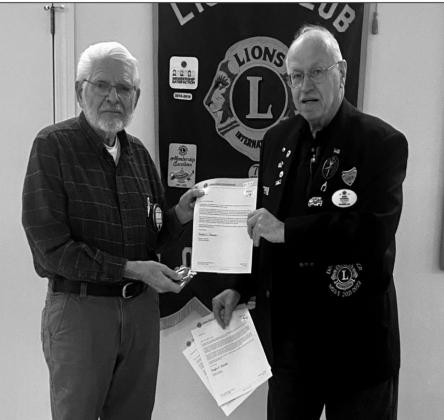 Walter Baker is presented an awardby District Governor David Wooddall for 15 years of service.