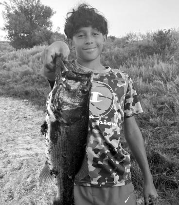 Brody Thibodeau with a largemouth bass he recently caught.