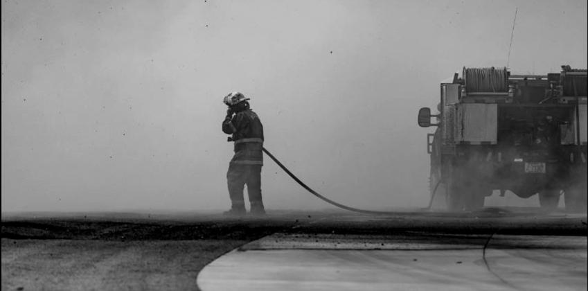 A firefighter works to extinguish a raging wildfire in early March 2025.