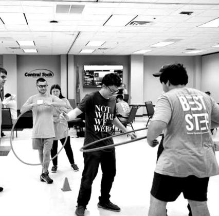 Campers test their teamwork skills by getting a hula hoop over a cone without using their hands.
