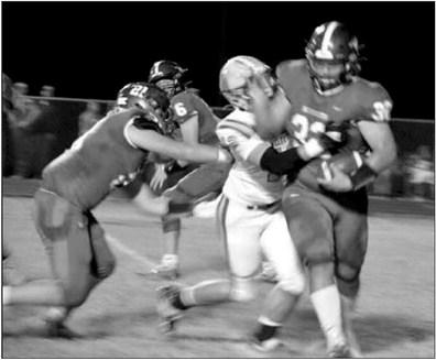 Seth McDaniel runs the ball as Brock McDaniel and Jess Smith play defense.