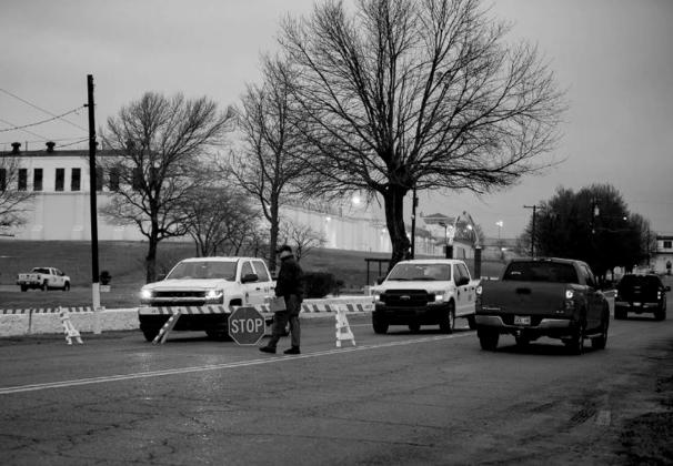 On days when the state executes an inmate, barricades block access to the Oklahoma State Penitentiary in McAlester. A guard is seen walking near one of the barricades a few hours before the state executed Gilbert Postelle on Feb. 17, 2022