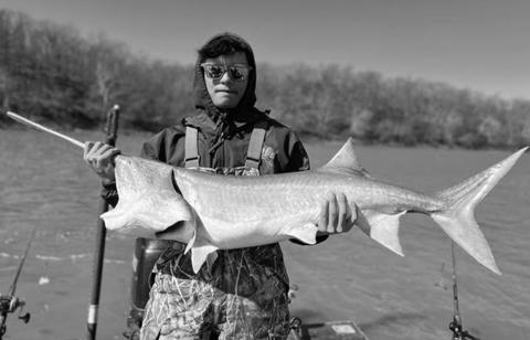 Devin Murfin holds a paddlefish caught at Grand Lake
