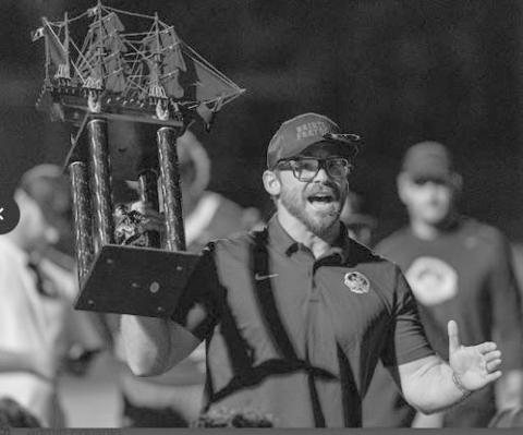 Coach Chris Jones proudly displays the Battle of the Boat’s trophy.