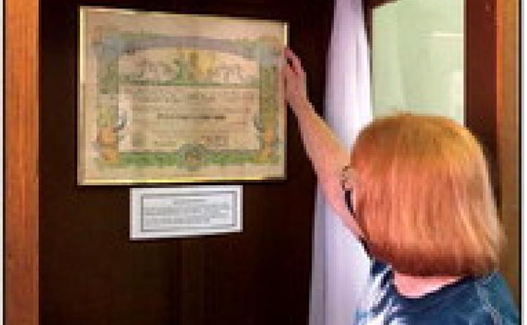 Georgia Smith adjusts an original document her father received in World War II